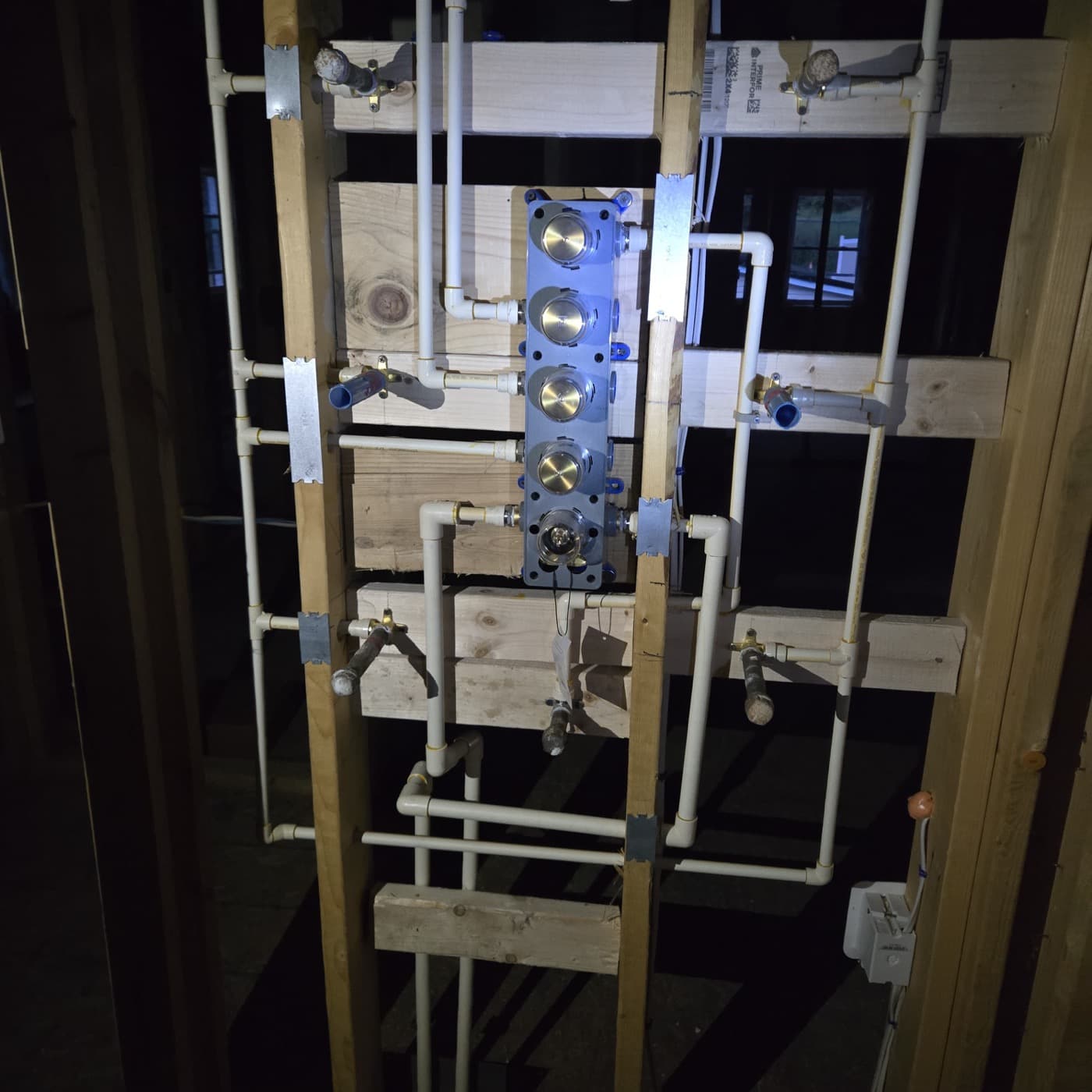 PEX plumbing manifold with valves — finish craftsmanship on a residential install